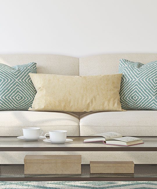 a white couch with blue pillows and a blue coffee table at The Westmount at Copper Mill