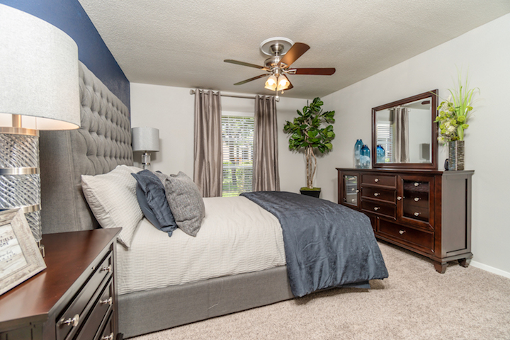 a bedroom with a ceiling fan and blue walls at The Westmount at Copper Mill