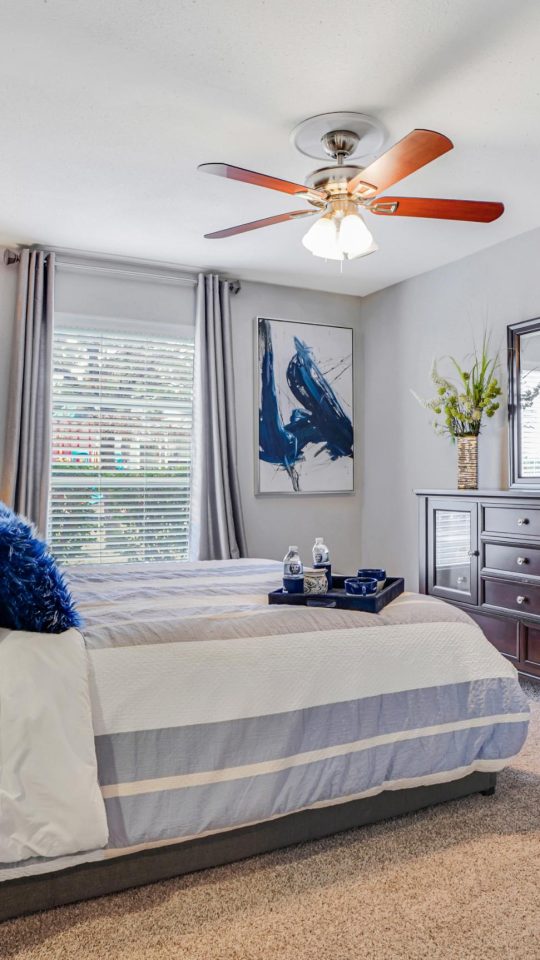 a bedroom with a ceiling fan and a bed at The Westmount at Copper Mill